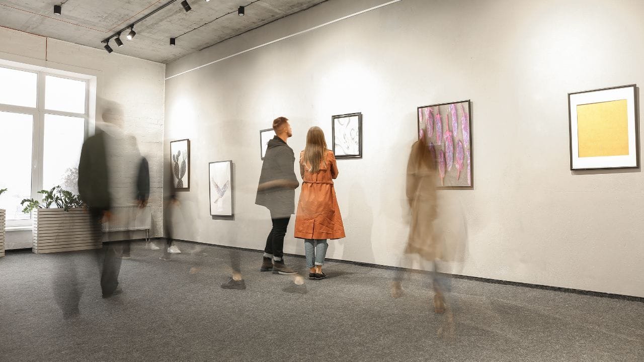 A group of people looking at art in an art gallery.