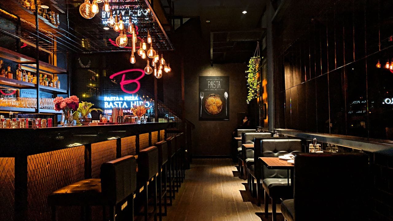 The interior of a restaurant with a bar and stools.