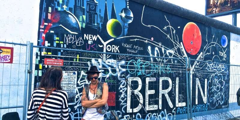 Two women standing in front of a graffiti wall in berlin.